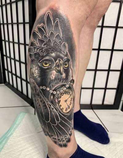 Neotradycjonalny tatuaż sowa na łydce wykonany w studiu Omerta Tattoo, Wrocław