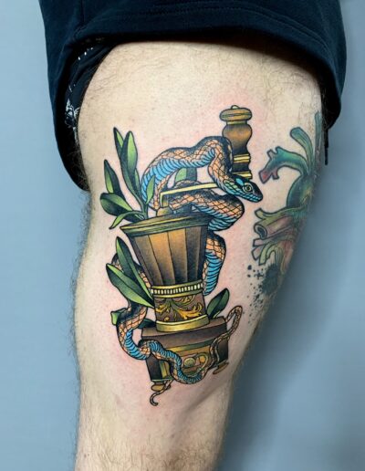 Neotradycjonalny, kolorowy tatuaż węża na udzie wykonany w studiu Omerta Tattoo, Wrocław