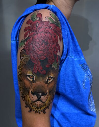Neotradycjonalny, kolorowy tatuaż lwa na przedramieniu wykonany w studiu Omerta Tattoo, Wrocław