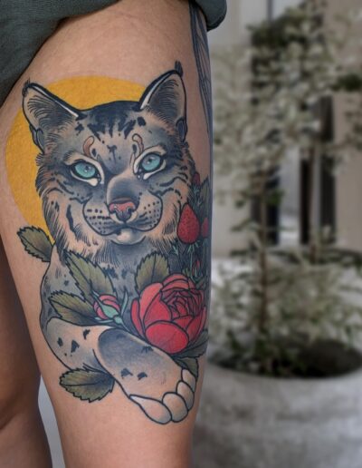 Neotradycjonalny tatuaż kota na udzie wykonany w studiu Omerta Tattoo, Wrocław