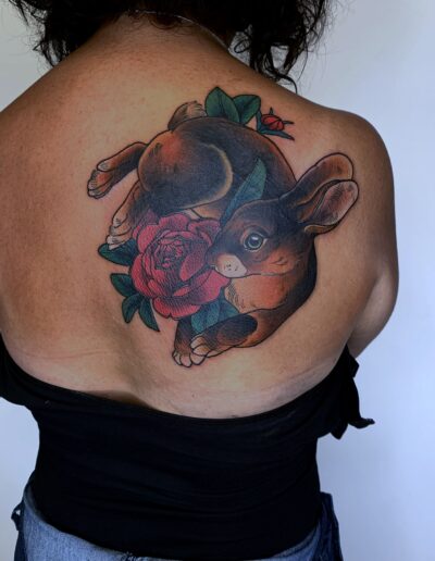 Neotradycjonalny tatuaż zająca w różach na plecach wykonany w studiu Omerta Tattoo, Wrocław