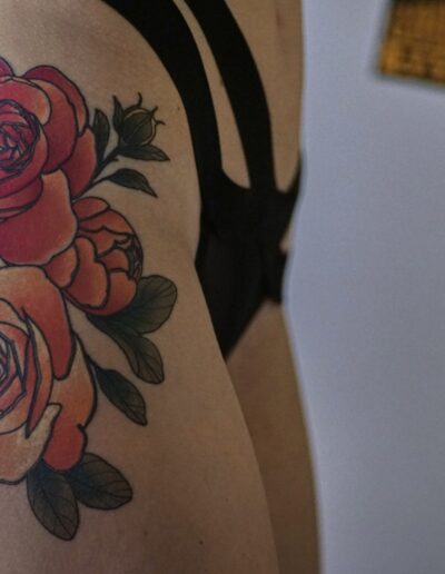 Neotradycjonalny tatuaż róż na biodrze wykonany w studiu Omerta Tattoo, Wrocław