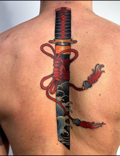 Neotradycjonalny tatuaż miecza samurajskiego na plecach wykonany w studiu Omerta Tattoo, Wrocław