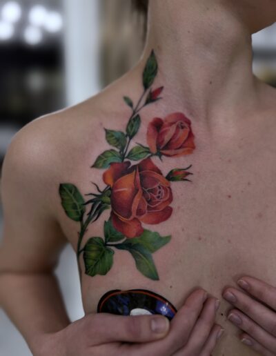 Kolorowy tatuaż róż na klatce piersiowej wykonany w studiu Omerta Tattoo, Wrocław
