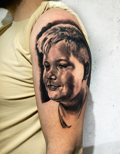 Tatuaż twarz dziecka na ramieniu