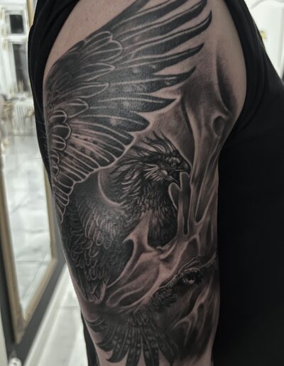 Realistyczny tatuaż feniksa na przedramieniu wykonany w studiu Omerta Tattoo, Wrocław
