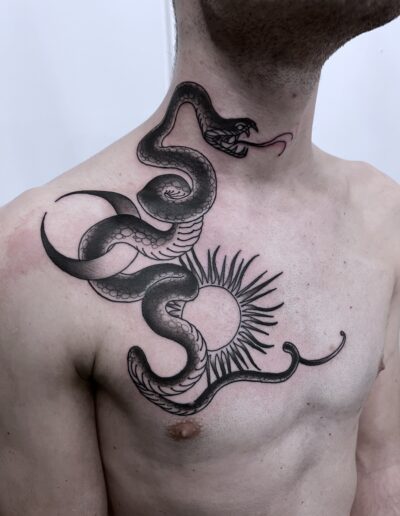 Konturowy tatuaż węża na klatce piersiowej wykonany w studiu Omerta Tattoo, Wrocław