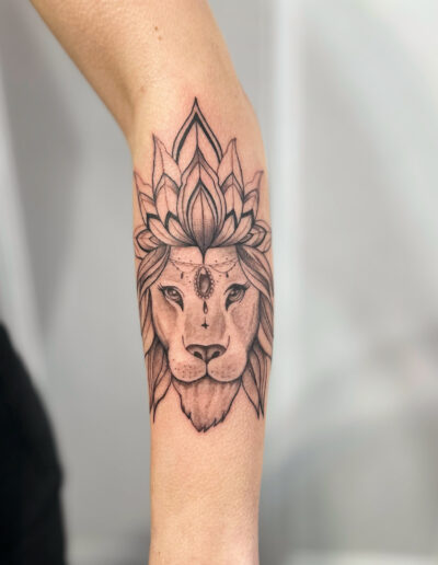 Minimalistyczny, konturowy tatuaż lwa - Mandala na przedramieniu wykonany w studiu Omerta Tattoo, Wrocław